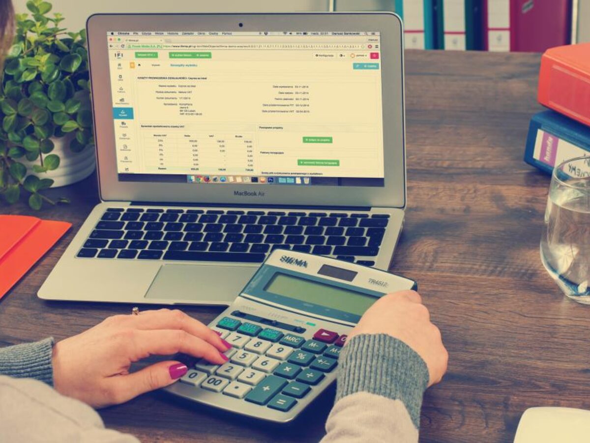 Persona revisando una planilla de costos con una calculadora