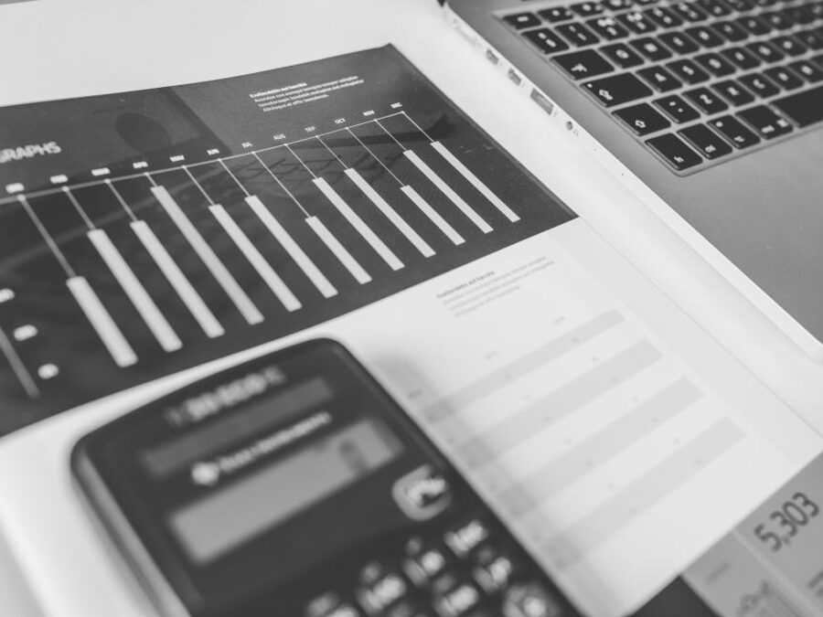 Informe impreso con gráficos de barras junto a una calculadora