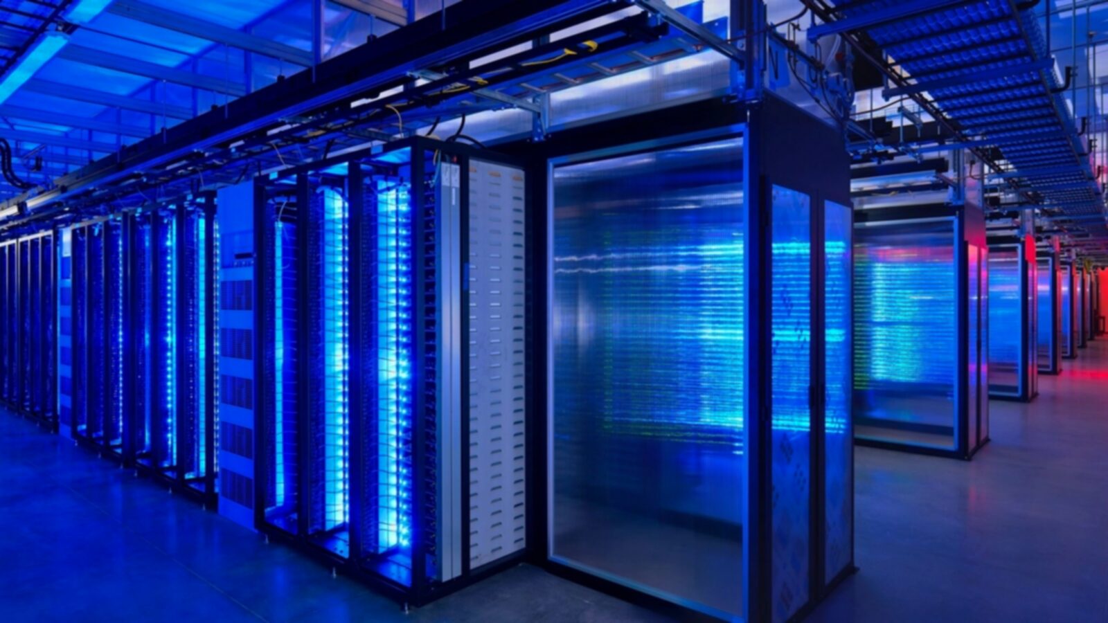 Pasillo de un centro de datos con racks de servidores iluminados en azul